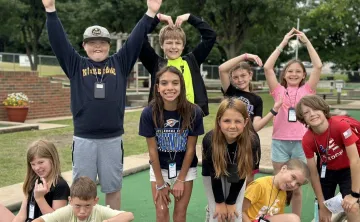 Kids in group making YMCA letters with arms